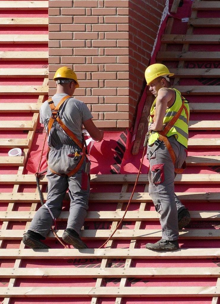 Professionele dakdekker voert werkzaamheden uit aan een dakkapel, demonstreert deskundigheid en vakmanschap