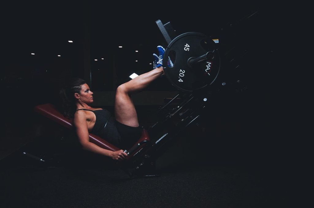 Personal trainer begeleidt lid bij training in sportschool Apeldoorn met moderne fitnessapparatuur